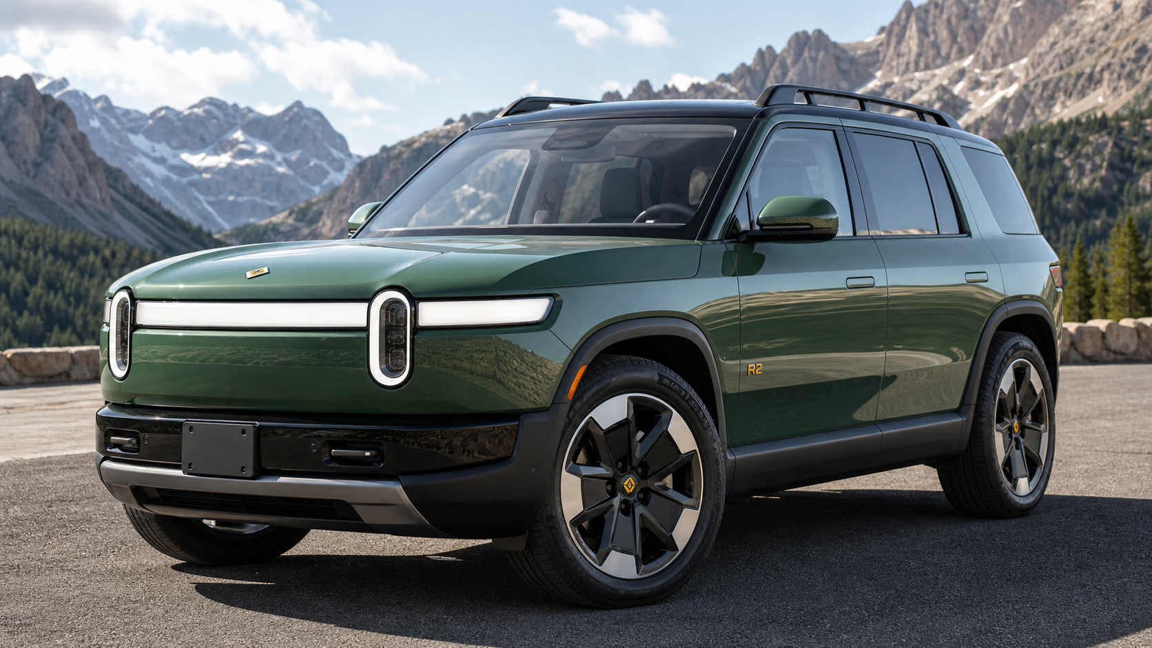 Rivian R2 electric SUV in Launch Green shown from the front three-quarter angle on a scenic mountain road.